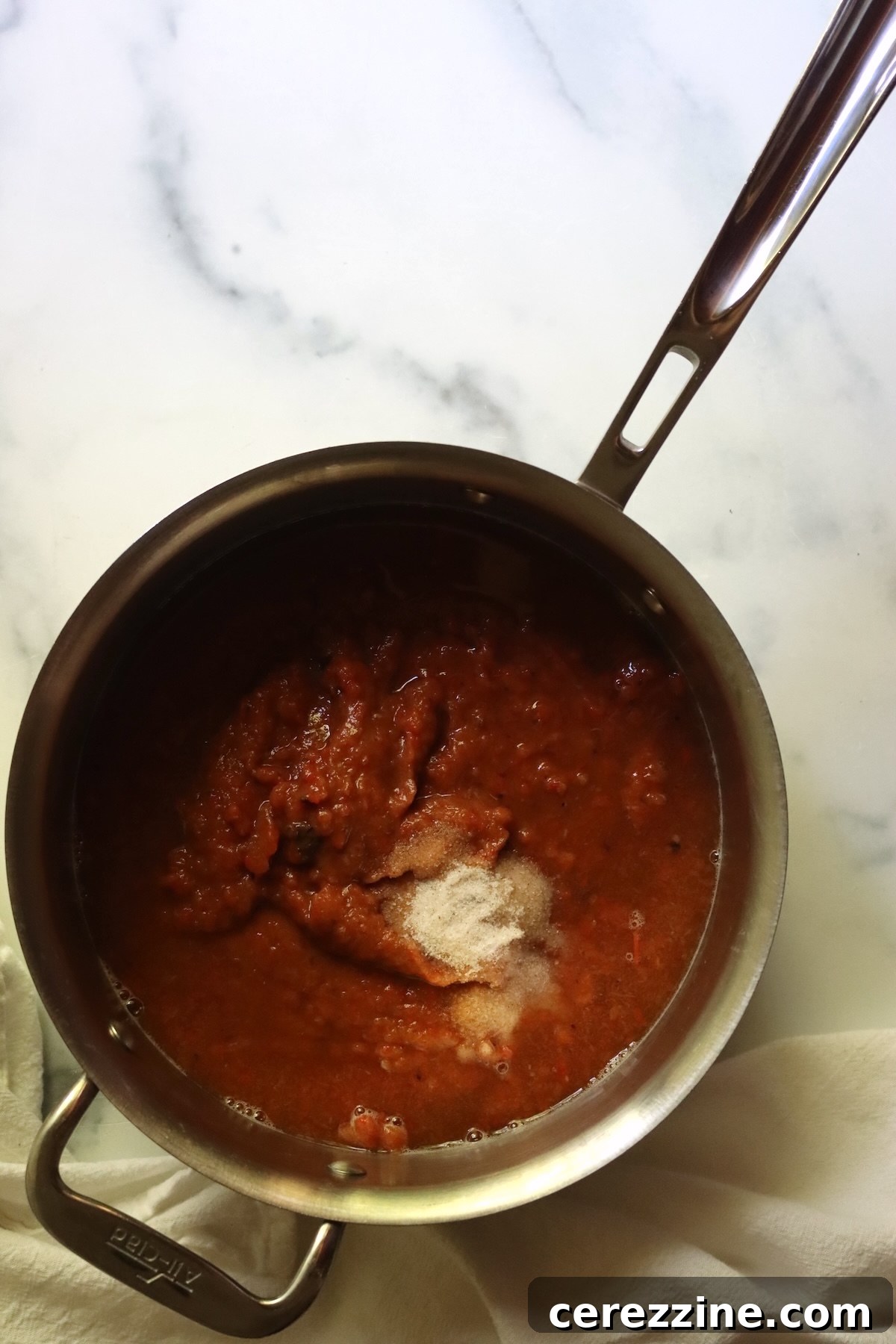 Pureed ajvar in a stainless steel saucepan, ready to cook with the vinegar